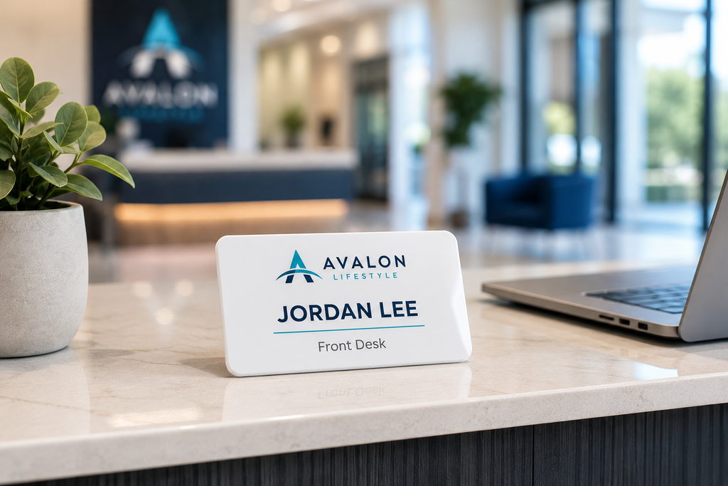 White acrylic name badge on a reception desk in a bright modern office lobby