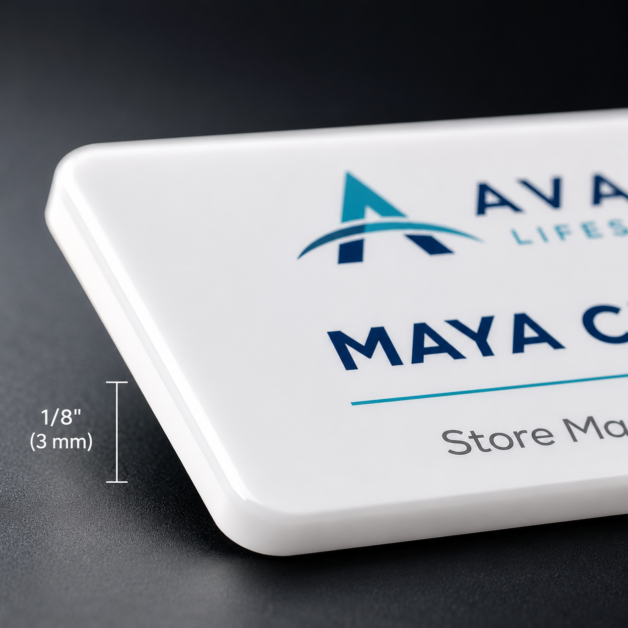 Macro close-up of a white acrylic name badge edge showing the 1/8 inch (3 mm) thickness