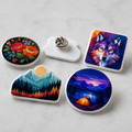 Set of custom white acrylic lapel pins in contour, round, and square shapes with pin backs