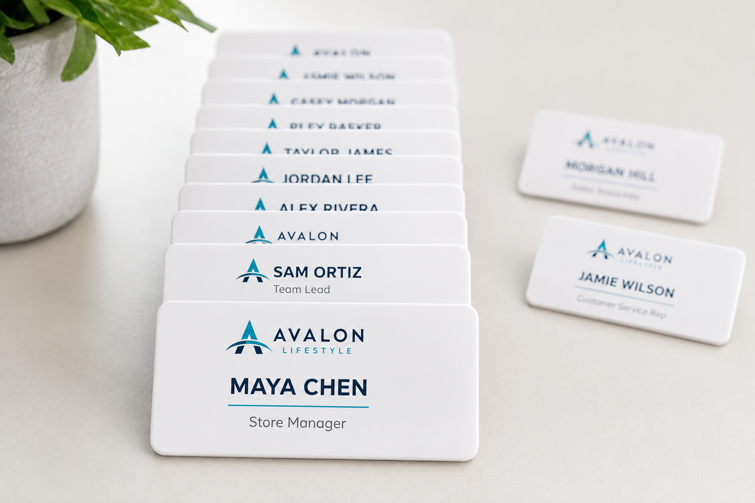 A team set of white acrylic name badges personalized with different names, fanned in list order