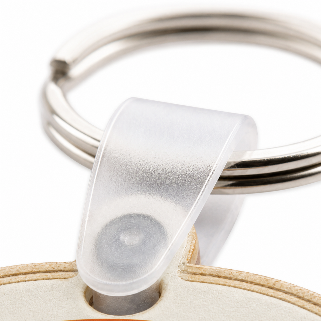 Macro detail of the clear plastic connector and stainless steel split ring attached to a birch wood keychain